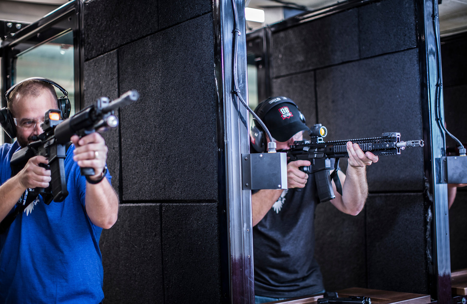 Two men point at gun at a shooting range
