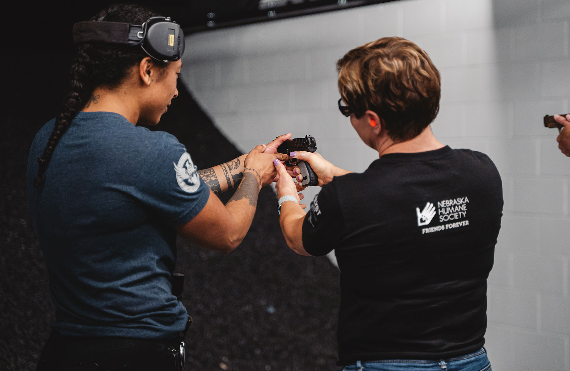 Handgun instructor shows women different parts of a handgun