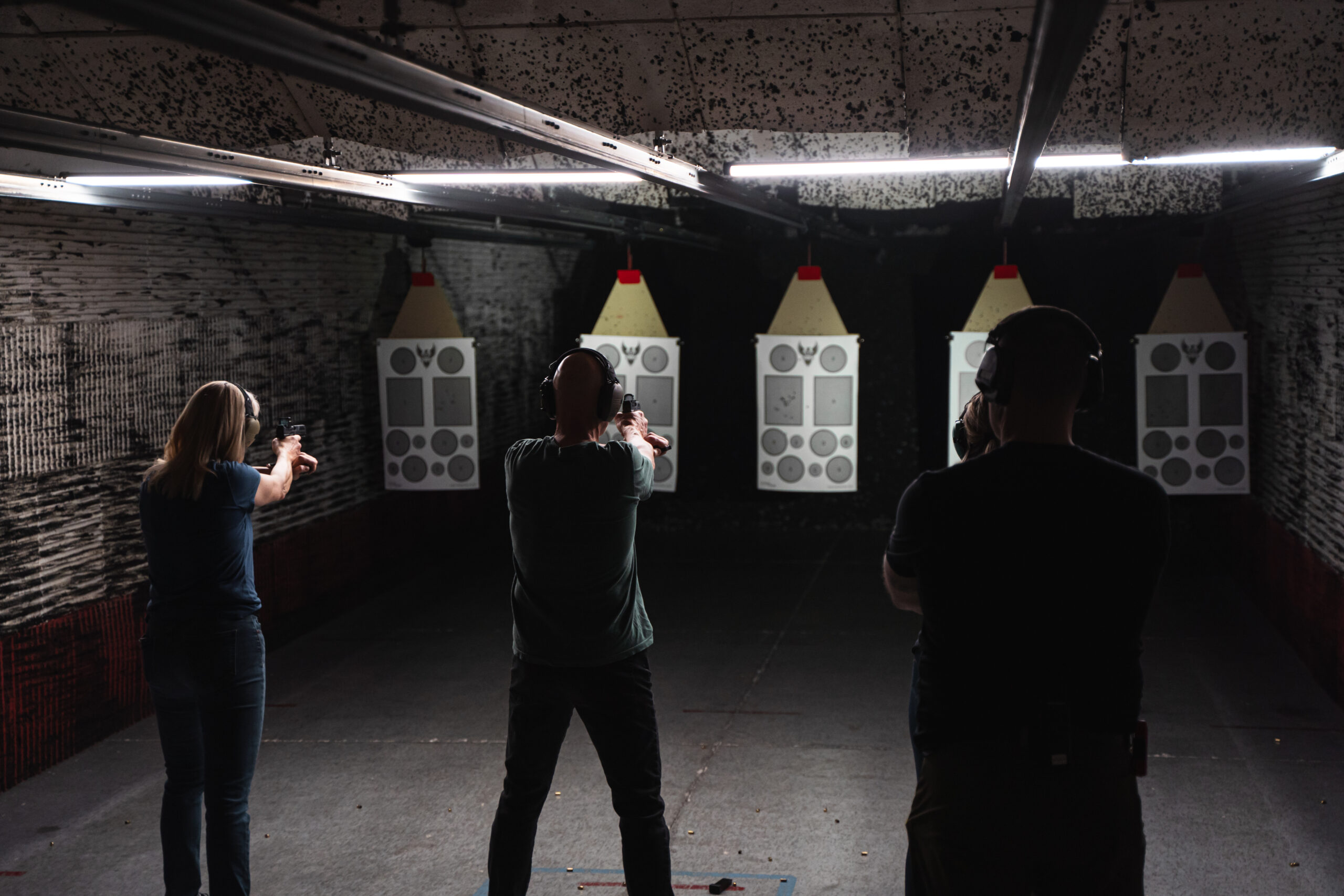 Three people shooting at targets